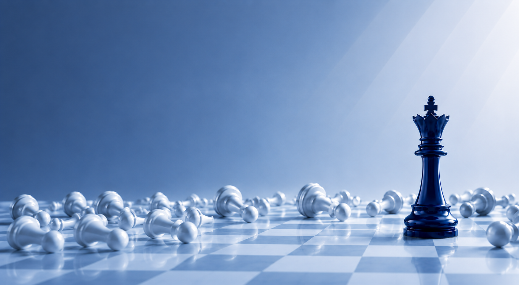 A navy chess king standing upright among fallen white chess pieces on a checkered board